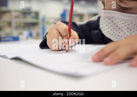 Pré-écrire enfant garçon faisant des exercices de calligraphie avec des livrets. Mise au point sélective Banque D'Images