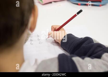 Pré-écrire enfant garçon faisant des exercices de calligraphie avec des livrets. Mise au point sélective Banque D'Images