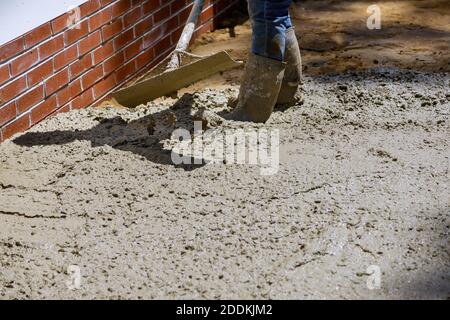 Mélangeur en béton pour les travailleurs avec ciment versant sur le trottoir résidentiel Banque D'Images