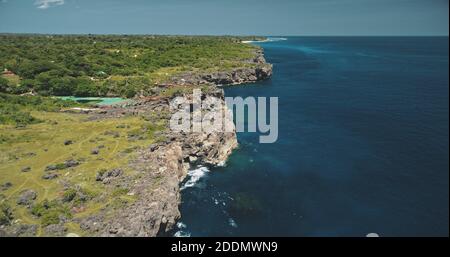 Côte côtière sur la falaise avec plantes vertes et arbres au lac azur limpid. Indonésie attraction avec bâtiment et pont sur la côte rocheuse de l'île de Sumba. Paysage tropical cinématographique avec tir de drone Banque D'Images