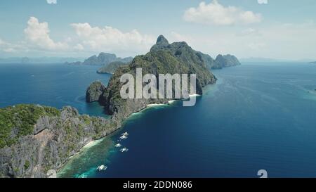 Vue aérienne sur les îles tropicales de l'archipel des Philippines. Croisière d'été sur les îles montagneuses. Bateaux à passagers traditionnels sur la côte bleue de la mer. Prise de vue cinématographique en lumière douce par drone Banque D'Images