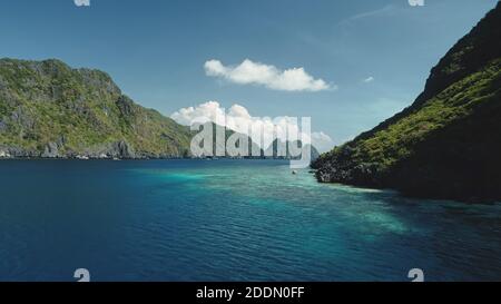 Vue aérienne de la baie de mer sur la falaise verte et sombre. Été personne paysage marin sur la côte rocheuse de l'océan avec turquoise et azur eau miroitant. Vacances épiques à Palawan, îles El Nido, archipel des Philippines Banque D'Images