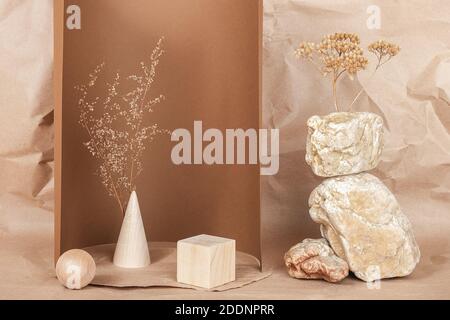 Podium créatif pour les cosmétiques ou vos marchandises, produits. Agencement fait de formes géométriques en bois, de pierres et de fleurs séchées sur papier beige brun Banque D'Images