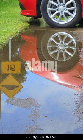 Réflexion de roue MAG dans une flaque de pluie printanière Banque D'Images