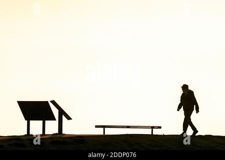 Los Angeles, États-Unis. 25 novembre 2020. Une silhouette d'homme marchant le long de Huntington Beach, Californie.Huntington Beach est également connu sous le nom de Surf City USA et est une destination de voyage dans le sud de la Californie. Crédit : SOPA Images Limited/Alamy Live News Banque D'Images