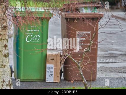 Poubelle de jardin verte et poubelle de déchets recyclables brune sèche sur un trottoir de Corby, en Angleterre, en attente de collecte. Banque D'Images