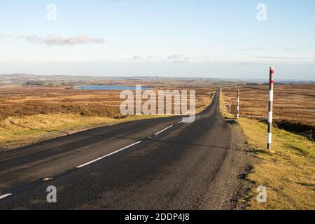 Vue d'automne de la route vide de la lande traversant Muggleswick Common à Weardale en direction de Castleside, Co. Durham, Angleterre, Royaume-Uni Banque D'Images