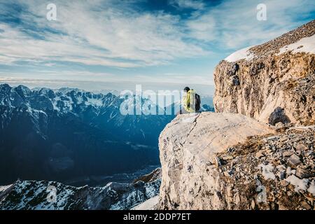 Dernières étapes avant le montage en sommet des serles. Grimpeur dans une veste jaune monte une montagne contre un ciel bleu. Vêtements d'alpinisme, Banque D'Images