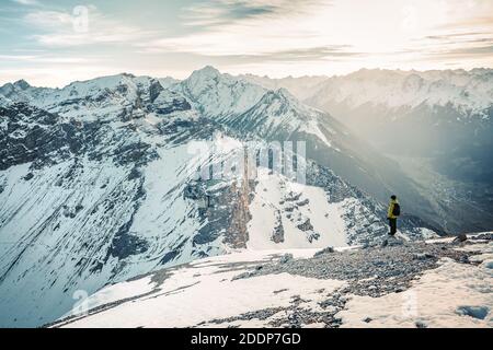 Dernières étapes avant le montage en sommet des serles. Grimpeur dans une veste jaune monte une montagne contre un ciel bleu. Vêtements d'alpinisme, Banque D'Images