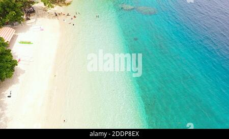 Drone aérien de Sandy Beach avec des touristes sur un atoll de corail dans l'eau turquoise. Canibad plage, Island Garden ville de Samal, Davao. Banque D'Images