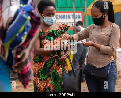 Les passagers doivent se désinfecter les mains avant d'entrer dans le bus à la gare routière de Giporoso. Remera, Kigali, Rwanda. Banque D'Images