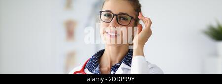 Jeune belle femme souriante médecin en lunettes avec stéthoscope autour son portrait du cou Banque D'Images