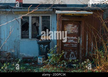 abri de jardin abandonné, ancienne porte cassée une fenêtre, poubelle Banque D'Images