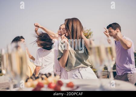 Photo de gaies jolis gars ont amusant dansant repas boissons sur la table de fête sur la terrasse du toit à l'extérieur Banque D'Images