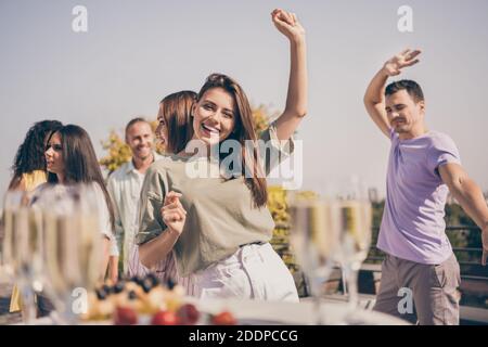 Photo de cool jolies filles les gars ont des repas de danse amusants des boissons sont servies à la table sur la terrasse du toit Banque D'Images