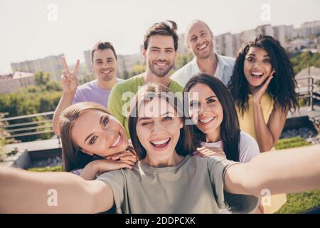 Photo de filles optimistes jolis gars faisant selfie montrer v-signe blink faites une fête sur la terrasse du toit Banque D'Images