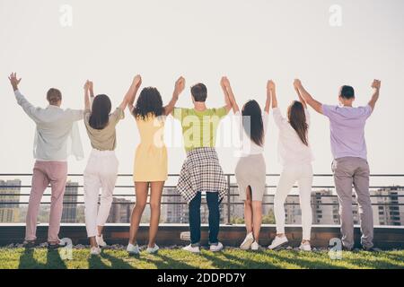 Photo d'optimistes jolies filles les gars de handsome debout tiennent les mains faites une fête sur la terrasse du toit à l'extérieur Banque D'Images