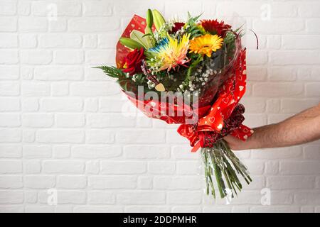Bouquet de fleurs différentes dans la main d'un homme Banque D'Images