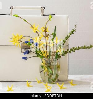 Bouquet de fleurs sauvages colorées dans un vase en verre et un porte-documents blanc, gros plan. Concept de printemps stylelife, magasins saisonniers Banque D'Images