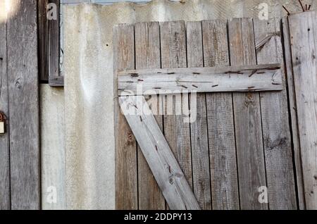 Ancienne porte en bois retirée sur le mur. Arrière-plan rétro et abîmé Banque D'Images