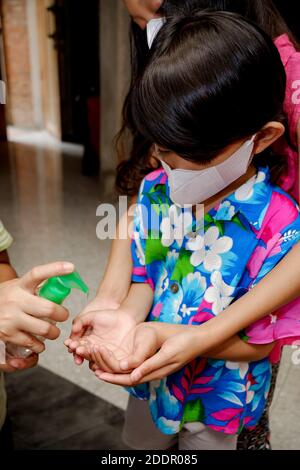 Enfants d'Asie du Sud-est utilisant un gel désinfectant liquide pour les mains. Protection contre les virus infectieux hygiène et mode de vie sain. Banque D'Images