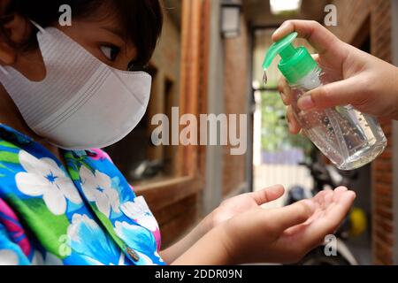 Garçon d'Asie du Sud-est utilisant du gel désinfectant liquide pour les mains. Protection contre les virus infectieux hygiène et mode de vie sain. Banque D'Images