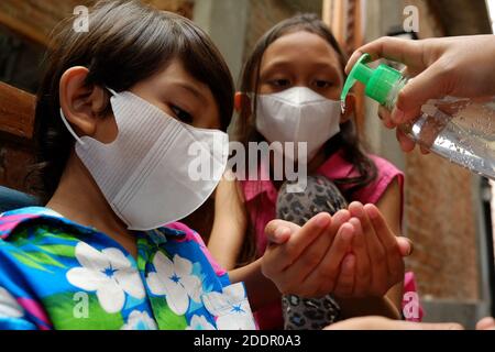 Enfants d'Asie du Sud-est utilisant un gel désinfectant liquide pour les mains. Protection contre les virus infectieux hygiène et mode de vie sain. Banque D'Images