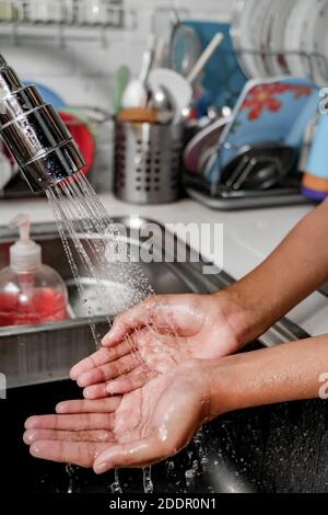 Gros plan image des mains lavées sous la douche d'eau sur un évier de cuisine pour la propreté et la santé. Un mode de vie sain Banque D'Images