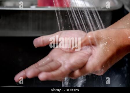 Gros plan mouvement flou image des mains lavées sous la douche de l'eau sur un évier de cuisine pour rendre la propreté et la santé. Un mode de vie sain. Banque D'Images