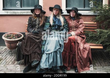 Deventer, pays-Bas, 15 décembre 2018 : trois jeunes femmes sur un banc pendant le festival Dickens à Deventer, aux pays-Bas Banque D'Images