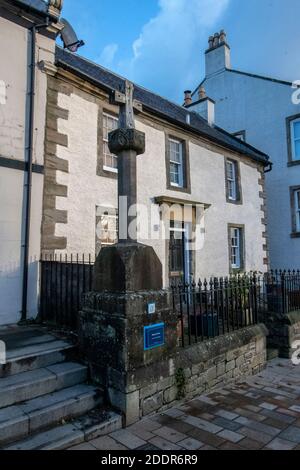 Kilwinning, Écosse, Royaume-Uni. 22 novembre 2020 : la Croix de Mercat en bois avec des bâtiments du XVIIe et XVIIIe siècle derrière elle. Banque D'Images