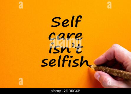 Il est temps de se soigner soi-même. L'écriture manuelle 'soin de self n'est pas égoïste', isolé sur un beau fond orange. Pandémie Covid-19 et concept médical. Copier l'espace Banque D'Images