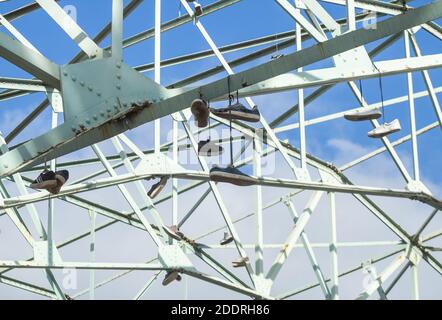 Anciennes baskets, chaussures d'entraînement suspendues à des poutres en acier, Banque D'Images