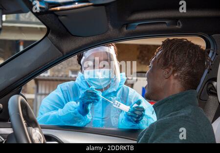 Sud de l'Angleterre, Royaume-Uni. 2020. Client noir au centre d'essai Covid-19 ayant un échantillon de siliva prélevé avec un coton-tige par un testeur femelle. Banque D'Images