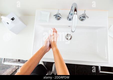 Femme se lavant les mains avec du savon sous l'eau courante de ci-dessus Banque D'Images