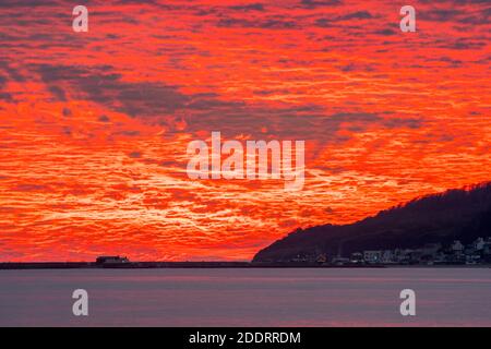 Charmouth, Dorset, Royaume-Uni. 26 novembre 2020. Un spectaculaire coucher de soleil rouge et flamboyant au-dessus du port de Cobb et de Lyme Regis à Dorset vu de la plage à Charmouth à la fin d'une journée ensoleillée crédit photo: Graham Hunt/Alamy Live News Banque D'Images