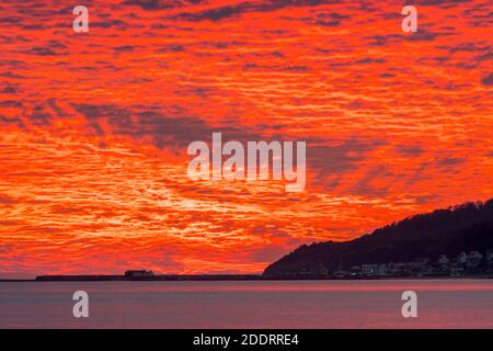 Charmouth, Dorset, Royaume-Uni. 26 novembre 2020. Un spectaculaire coucher de soleil rouge et flamboyant au-dessus du port de Cobb et de Lyme Regis à Dorset vu de la plage à Charmouth à la fin d'une journée ensoleillée crédit photo: Graham Hunt/Alamy Live News Banque D'Images