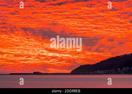 Charmouth, Dorset, Royaume-Uni. 26 novembre 2020. Un spectaculaire coucher de soleil rouge et flamboyant au-dessus du port de Cobb et de Lyme Regis à Dorset vu de la plage à Charmouth à la fin d'une journée ensoleillée crédit photo: Graham Hunt/Alamy Live News Banque D'Images