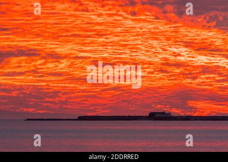 Charmouth, Dorset, Royaume-Uni. 26 novembre 2020. Un spectaculaire coucher de soleil rouge et flamboyant au-dessus du port de Cobb et de Lyme Regis à Dorset vu de la plage à Charmouth à la fin d'une journée ensoleillée crédit photo: Graham Hunt/Alamy Live News Banque D'Images