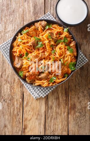 Goulash Szekely Gulyas ou Szegedin avec du porc, des oignons et de la choucroute dans un bouillon de paprika à proximité de la plaque sur la table. Vue verticale du dessus de l'abov Banque D'Images