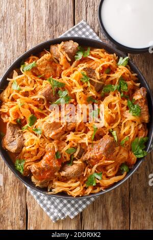 Le Goulash hongrois Szegedin présente du porc succulent et mijoté, des oignons et de la choucroute dans un bouillon de paprika merveilleusement riche et infusé dans l'assiette sur le t Banque D'Images