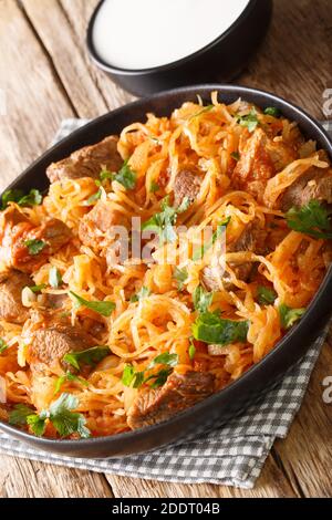 Le Goulash hongrois Szegedin présente du porc succulent et mijoté, des oignons et de la choucroute dans un bouillon de paprika merveilleusement riche et infusé dans l'assiette sur le t Banque D'Images