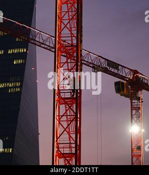 26 novembre 2020, Hessen, Francfort-sur-le-main: Un opérateur de grue de construction descend le mât dans la lumière du soir sur un chantier de construction non loin de la BCE dans l'est de Francfort. Photo: Arne Dedert/dpa Banque D'Images