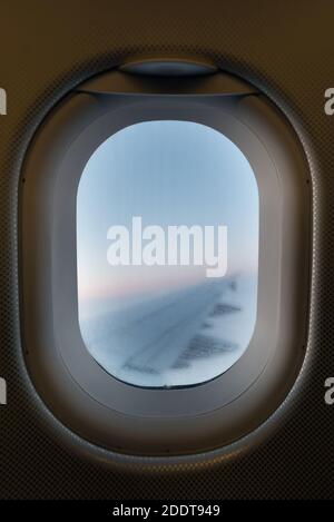 Fenêtre d'avion donnant sur l'aile droite vue de l'intérieur de l'avion en vol. Se concentrer sur la fenêtre. Banque D'Images