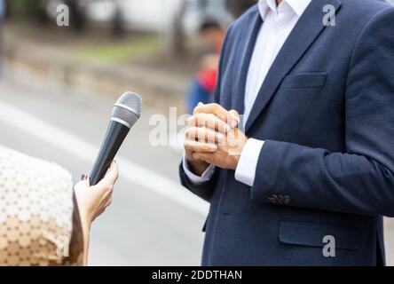 Journaliste faisant un entretien de presse avec une personne méconnaissable. VOX populi concept. Banque D'Images