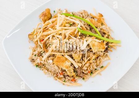 Cuisine péruvienne, riz frit « Arroz chaufa » avec wantan sur fond blanc Banque D'Images