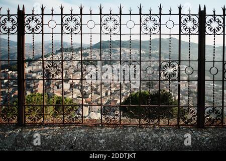 Au-delà d'une balustrade en fer forgé paysage urbain flou sur la montagne Mistretta Ville de Sicile preuve d'art et de culture Banque D'Images