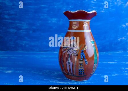 Vase brun de style égyptien ancien sur fond bleu. Banque D'Images