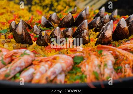 Paella jaune cuite avec crevettes, muse, riz dans une grande casserole - gros plan Banque D'Images