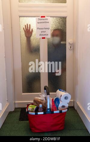 Image symbolique quarantaine domestique, homme suspecté d'infection corona, à la maison isolée, signe d'avertissement pour les visiteurs à la porte plate, communiqué Banque D'Images